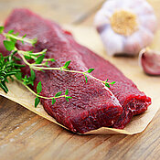 Lammlachse mit Thymian und Knoblauch auf Holzunterlage