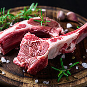 2 Stücke Lammkotelett auf hölzernem Schneidbrett