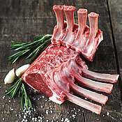 2 Stücke Lammkarree auf Holzplatte