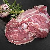 Lammkeule mit Rosmarin und Knoblauch auf schwarzer Steinplatte